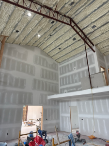 Two story great room with hung and taped drywall before painting